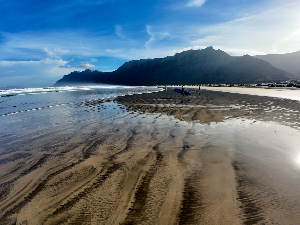 Playa de Famara Plaža Famara z valovi Atlantika in pogledom na klife Risco de Famara